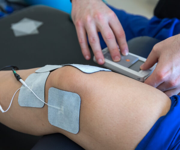 electronic therapy on knee used to treat pain. selective focus